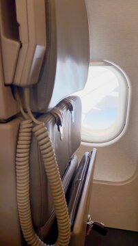 Airplane cabin interior with view through window on a sunny day