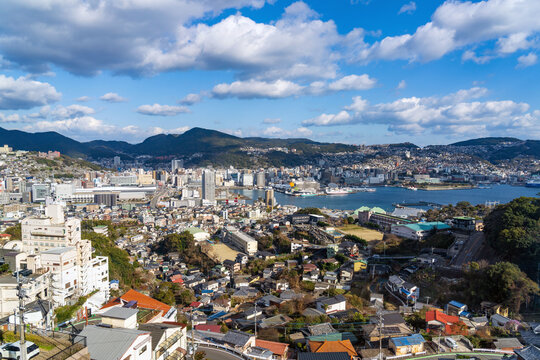 Expansive Nagasaki cityscape and Nagasaki Port framed by clear blue sky from Mount Inasa