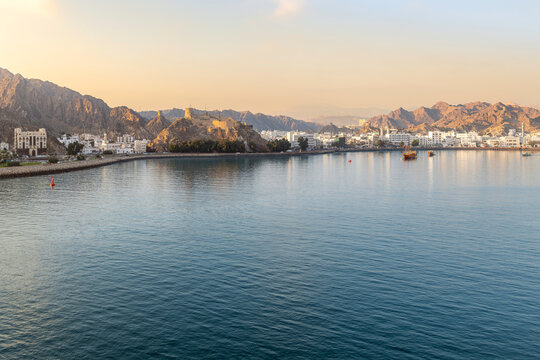 Morning sunlight across the Mutrah Corniche waterfront promenade and Mutrah Fort in the historic area along the Gulf of Oman, in Muscat Oman.