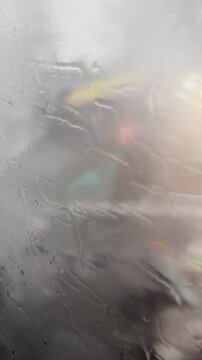 Abstract view of rainy day through a wet window with blurred background