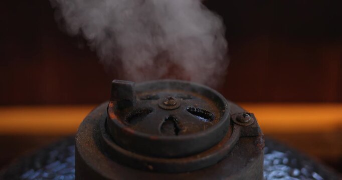 steam comes from a closed grill while cooking meat, colorful flowers in the background
