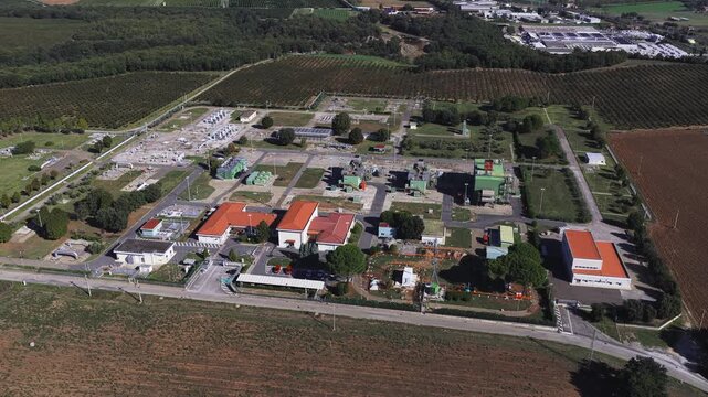 Aerial view of the Snam Rete Gas compression station featuring industrial facilities, pipelines, and surrounding agricultural fields in Gallese, Lazio, Italy.