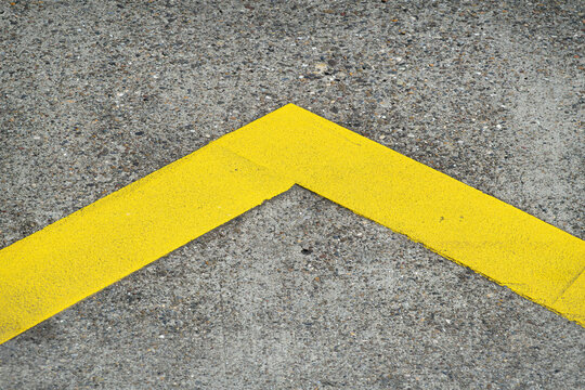 Yellow angle marking on gray concrete pavement