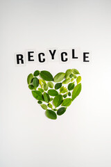 Obraz premium Recycle message with heart shape made of green leaves on white background, sustainability concept