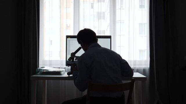 Scientist silhouette working at a desk with microscope and computer, conducting research and analysis in a modern lab or home office, focused on discovery and precision