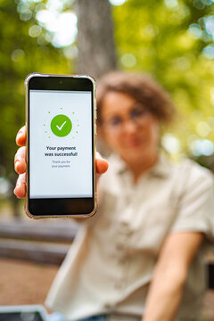 Person holding smartphone displaying successful digital payment transaction