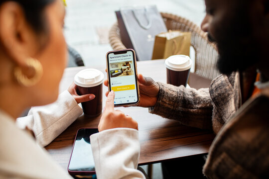 Travelers using smartphone to check in at cafe table
