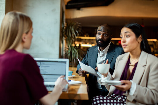 Business colleagues discussing documents over coffee in a cafe