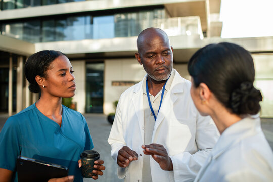 Doctors and nurse discussing case outside hospital