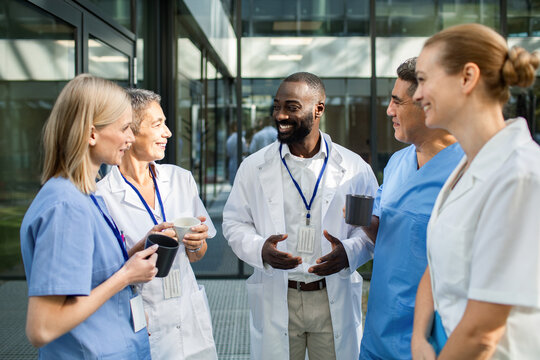 Healthcare professionals having coffee and conversation outside hospital
