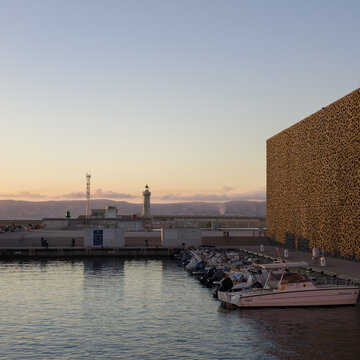 MARSEILLE, FRANCE - SEPTEMBER 16, 2026 - MuCEM museum and boats moored in the Old Port of Marseille at sunset