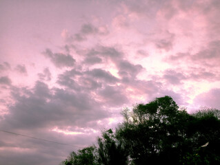 Fototapeta premium Sunset cloudy sky with the orange sun
