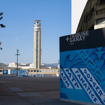 MARSEILLE, FRANCE - SEPTEMBER 16, 2026 - Sign for Tribune Ganay at Orange Velodrome with Tour CMA CGM tower in Marseille, France