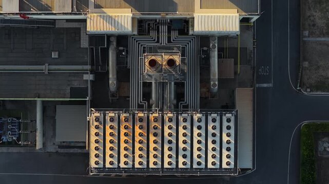 Aerial view of industrial cooling system with rows of fans and pipes on a rooftop in Rome, Lazio, Italy.