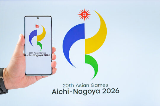 ZhongShan GuangDong China-September 18 2026: Hand holding a smartphone showing the 20th Asian Games Aichi-Nagoya 2026 official emblem.