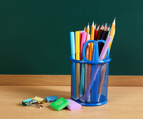 Different stationery on wooden table near chalkboard © New Africa