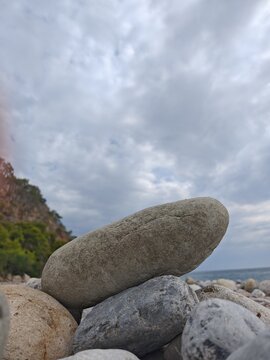 Smooth rock formation on cloudy coastal landscape
