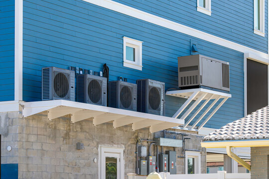 Standby backup generator with automatic transfer switch and outdoor HVAC mini split units on building in USA