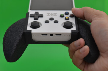 Person holding retro handheld game console with black 3D printed grip © ahmadiliandy