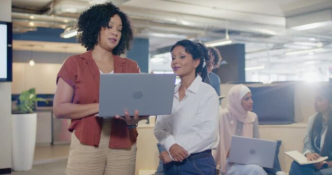 Diverse women colleagues reviewing laptop, lead opening it and showing data in office to align
