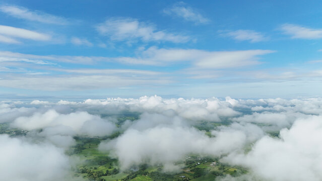 High above, clouds drift over  green valley