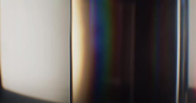 Colorful light refraction of smooth reflective glass prism with lens chromatic aberration and optical distortion effects in a rainbow of colors. Shining lights reflect highlights on angled glass Loop