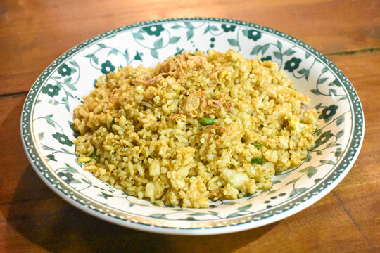 Indonesian fried rice nasi goreng garnished with crispy shallots on vintage ceramic plate