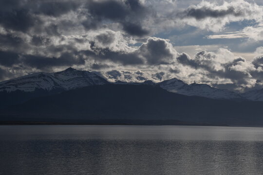 Monta&ntilde;as nevadas y cielo dram&aacute;tico sobre el Estrecho de Magallanes en Puerto Natales
