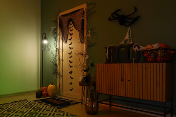 Halloween home decor, festive interior with pumpkins and spooky decorations for autumn holiday celebration in a cozy living room with dim lighting © Pixel-Shot