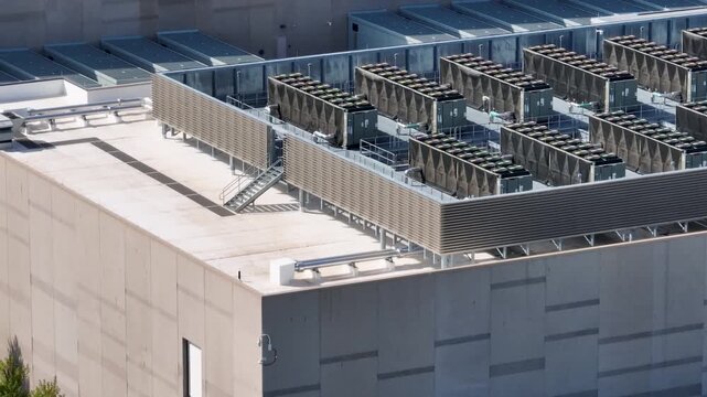 Aerial view of a data center roof featuring rows of industrial HVAC cooling units and ventilation systems