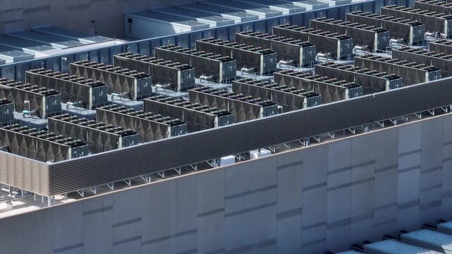 Aerial view of rows of industrial cooling units on a large data center rooftop