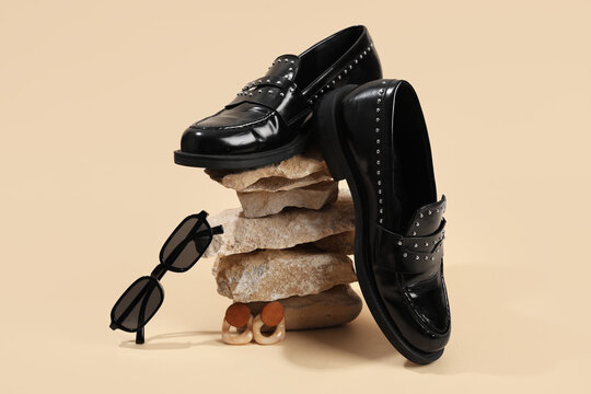 Fashion trends and luxury style, black studded loafers with sunglasses and earrings on stacked stones for modern retail and editorial photography