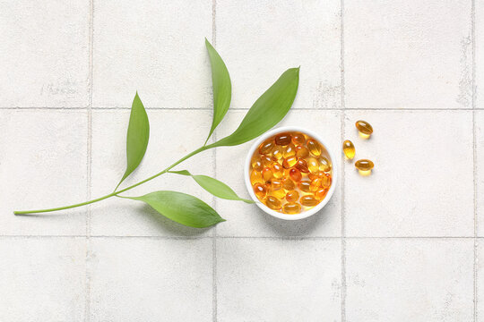 Natural wellness and dietary supplements, omega 3 fish oil capsules in a bowl with green leaves for holistic health and organic nutrition