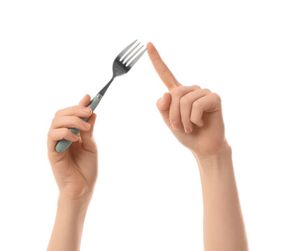 Dieting and hunger control, person holding a fork with finger pointing to tines for portion awareness and mindful eating habits on white background