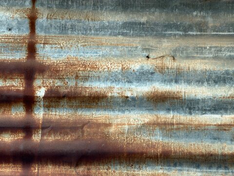 Close up weathered and oxidized old zinc wall, industrial grunge style texture background showing rust and aged metal surface pattern