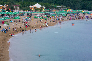 Fototapeta premium Evening Beachgoers at Fujiazhuang Beach