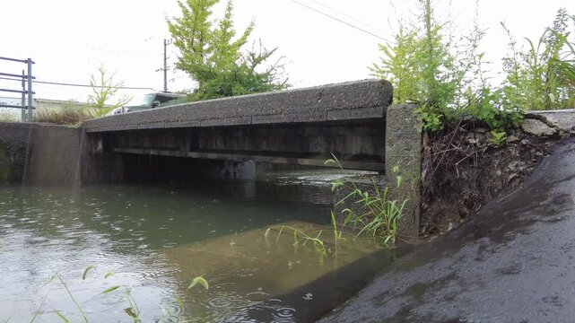 大雨で川が増水して橋までの距離が近くなっている