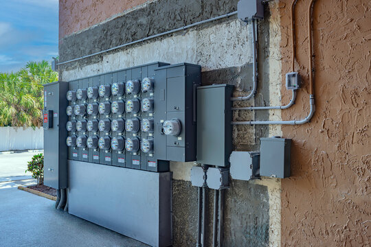 Outdoor commercial electric meter bank and main disconnect panels on apartment building exterior in USA
