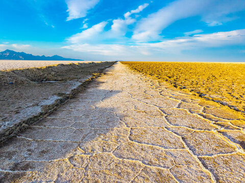 Earthen berm divides vast salt flats landscape in Utah