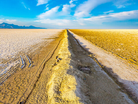 Earthen berm divides vast salt flats landscape in Utah
