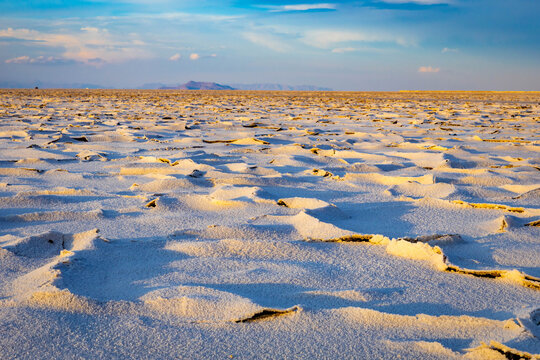 Golden sunrise illuminating textured crust at Bonneville Salt Flats Utah