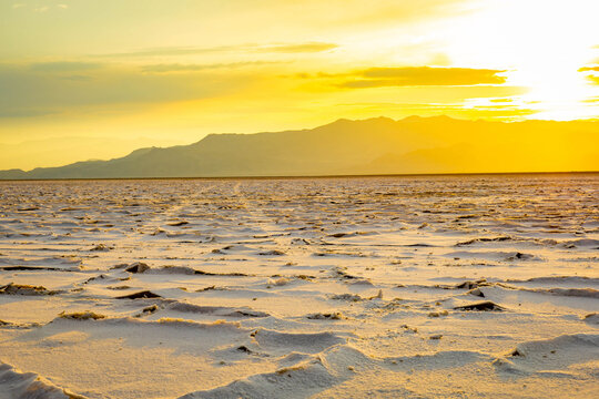 Golden sunrise illuminating textured crust at Bonneville Salt Flats Utah