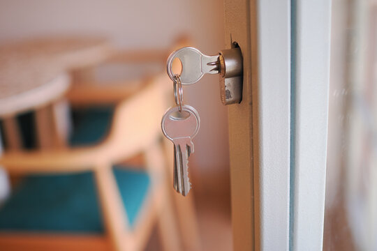 The lock has keys that are currently inserted into the keyhole of the door