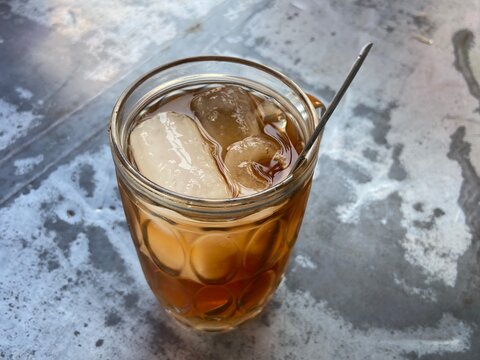 Glass of Iced Tea With Spoon On A Wet Table
