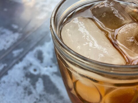 Glass of Iced Tea With Spoon On A Wet Table