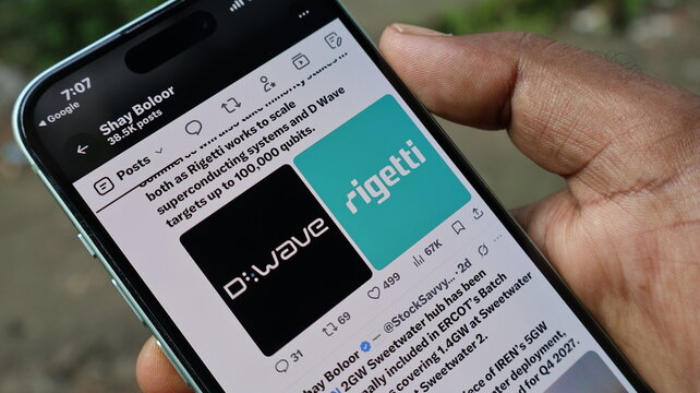 Smartphone screen showcasing D-Wave and Rigetti quantum computing logos on social media feed held in hand outdoors. Kolkata, West Bengal, India, September 11, 2026