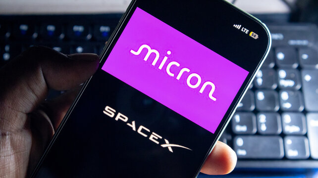 Micron and spacex corporate branding logos shown on mobile phone screen for memory technology and aerospace industry news.