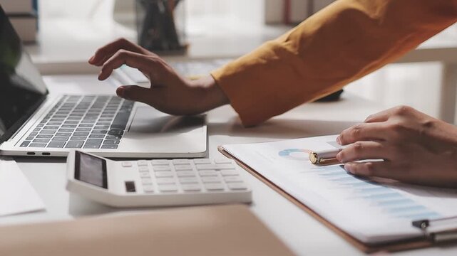 Businesswoman holding document working at laptop pc computer doing online tax invoice, financial report. Focused Hispanic business woman manager specialist with paperwork in office. Banner, copy space
