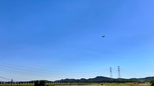 Cinematic 4K shot of a large passenger airplane flying through the blue sky