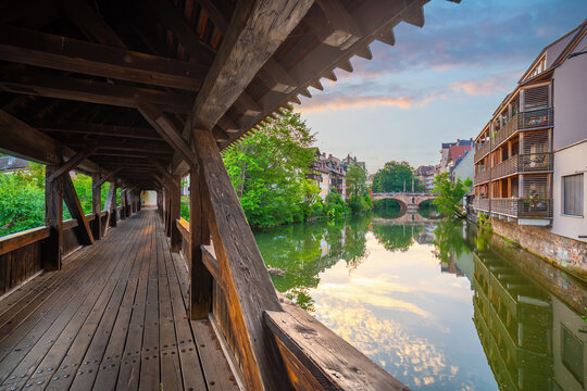 Stunning sunset view of the historic Weinstadel, Henkersteg wooden bridge  reflecting in the calm waters of the Pegnitz River in Nuremberg